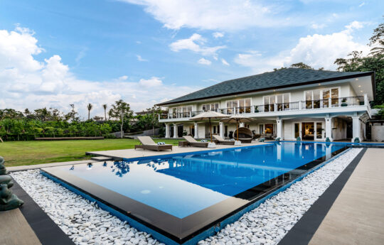 Large lap pool of villa with villa in background