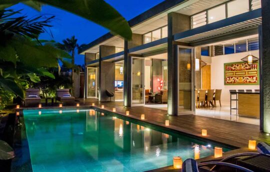 View of swimming pool and villa Damai exterior at night