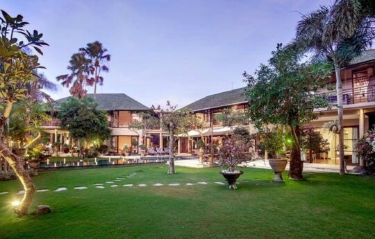 Large garden area of Villa Avalon with trees and villa exterior