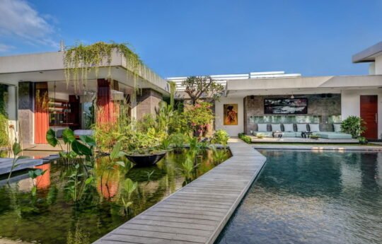Swimming pool at night with view of Villa Banyu exteriors in background with lights on
