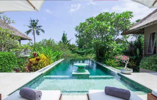 Two day beds and swimming pool of Villa Inti during the day