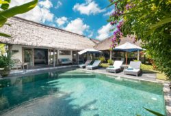 Sunny pool views of Villa Damai Manis with day beds and alang alang roof