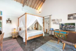 Lovely comfortable bedroom with artwork on walls and bed