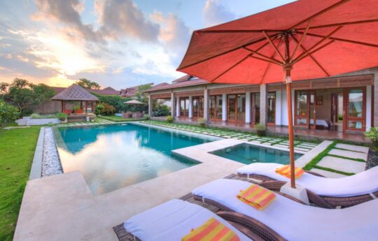 Pool views and villa exterior of Villa Griya Aditi with Ubud skyline
