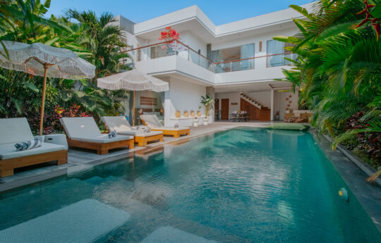 View of the pool and garden area of Villa Noya with entire 2 level villa in background