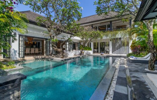 Villa Senang's swimming pool views with garden and villa in background during daytime