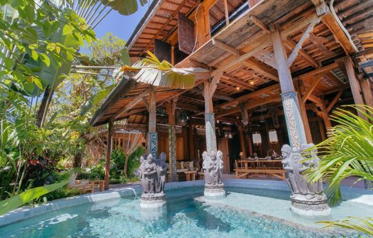 View to wooden villa exterior with swimming pool and garden in foreground on sunny day