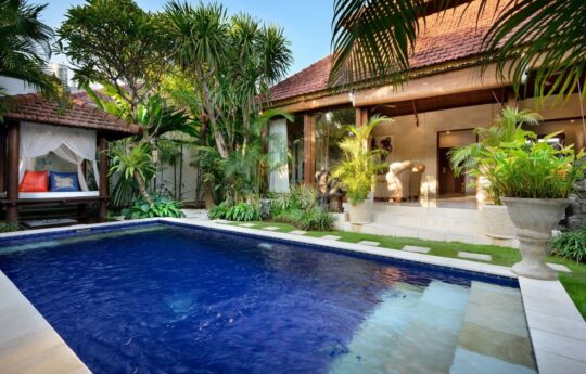 Villa Istana Satu pool and daybeds in foreground with villa living areas