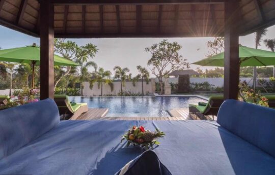 View of Villa Luwih's swimming pool area from the gazebo at sunset