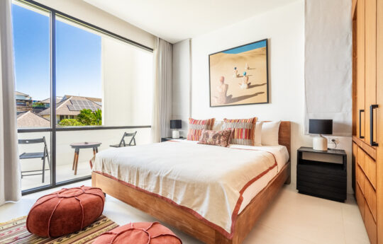 private bedroom of villa with queen bed and balcony