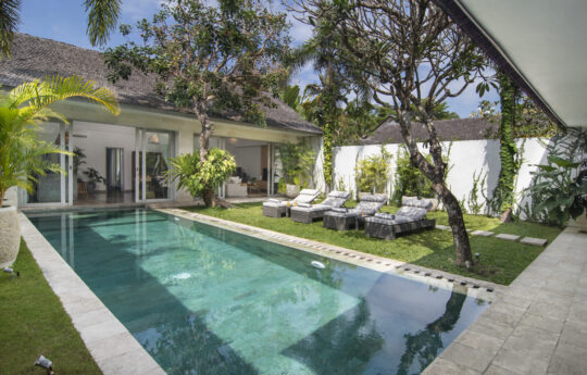 Swimming pool on sunny day with day beds