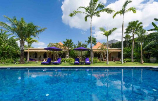 Pool views of Villa Sayang D'Amour with villa exteriors during sunny day