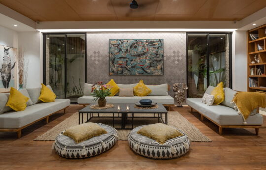 Lounge room with three sofas and two large cushions