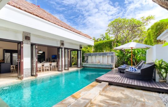 Swimming pool, deck area with daybeds and Villa Amala interiors in background