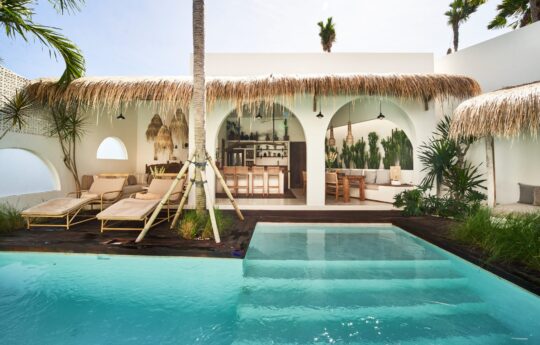Swimming pool views with outlook of villa interiors during day