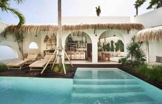View of interior kitchen areas with swimming pool in foreground during sunny day