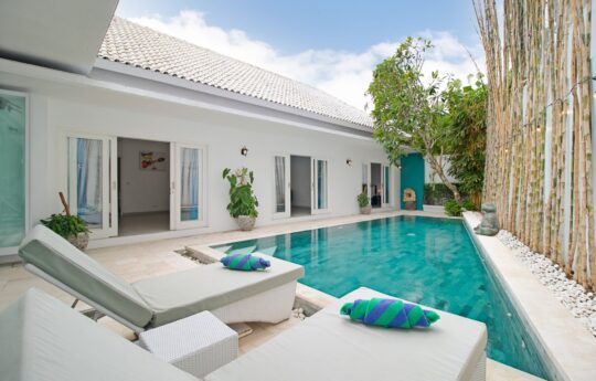 Pool area with two daybeds and view to bedrooms at Villa Brightside in Canggu