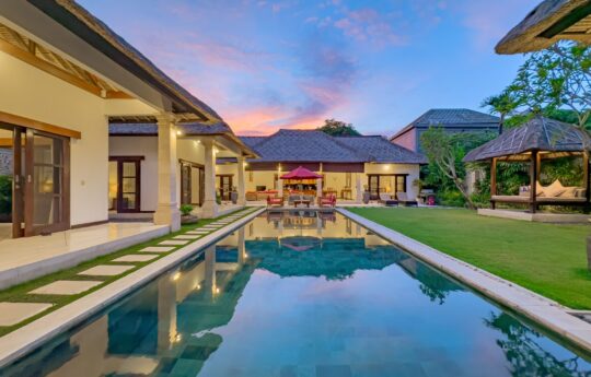 Swimming pool and exteriors at dusk with garden and gazebo