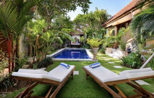 Villa Istana Satu pool and daybeds in foreground with villa living areas