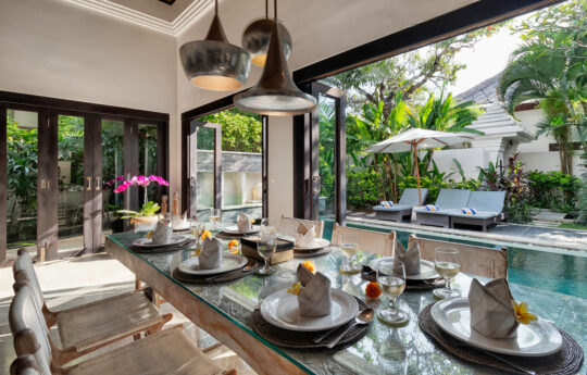 Dining table with plates with views to pool area