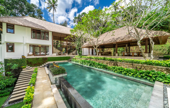 View of swimming pool and two level villa exterior