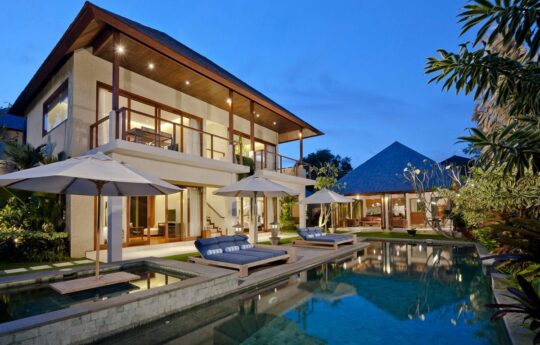 Villa exterior at night with lights on at dusk