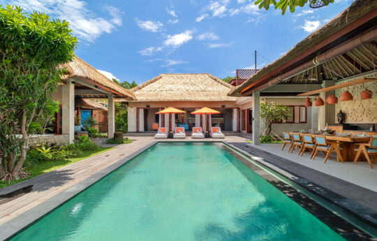 Swimming pool view of sunny day with villa exterior