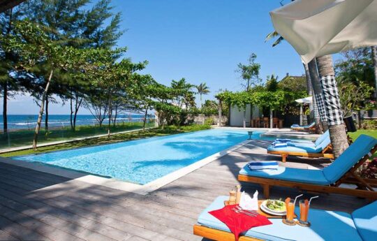 Villa Puri Nirvana swimming pool and deck area with daybeds on a sunny day