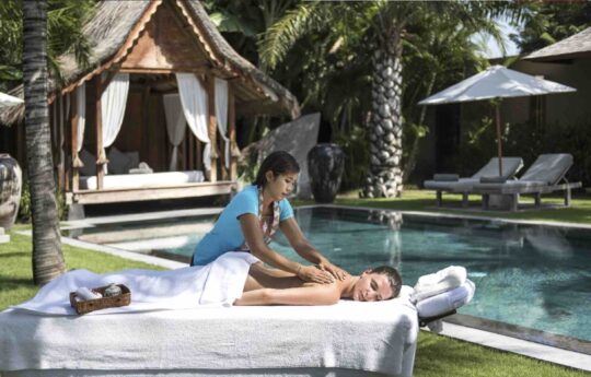 Women getting massage by the pool at Villa Tiga Puluh